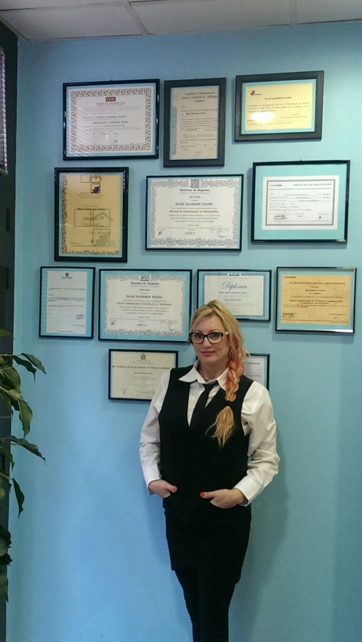 Silvia Salmerón, Directora de Asesoría Esplugues, frente a una pared con diplomas y certificaciones.